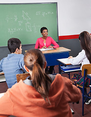 Image showing Teacher And Teenage Students Sitting In Classroom