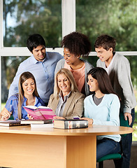 Image showing College Teacher Explaining Lesson To Students In Classroom