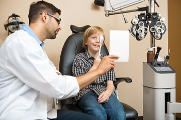 Image showing Boy Covering Eye with Occluder at Optometrist