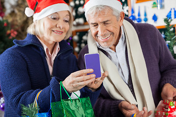 Image showing Senior Couple Using Mobilephone At Christmas Store