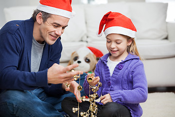 Image showing Father And Daughter Looking At Christmas Decorations