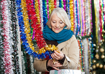 Image showing Woman Shopping For Tinsels At Christmas Store