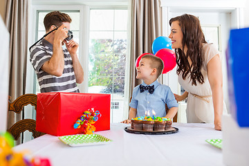 Image showing Father Taking Picture Of Birthday Boy And Woman