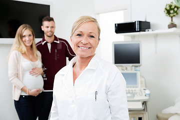 Image showing Happy Doctor With Expectant Couple In Background