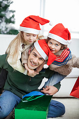 Image showing Father Piggybacking Children During Christmas