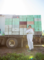 Image showing Beekeeper Standing Against Truck Loaded With Honeycomb Crates