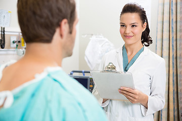 Image showing Doctor With Clipboard Smiling At Patient