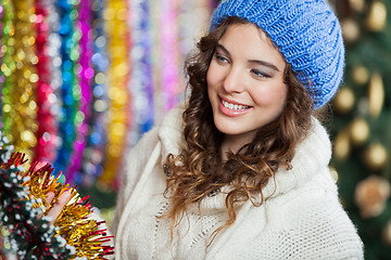 Image showing Young Woman Choosing Tinsels At Store