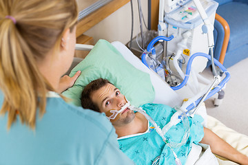 Image showing Patient Looking At Nurse As She Adjusts His Pillow