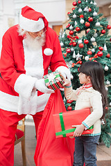 Image showing Santa Claus Giving Gifts To Girl