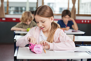 Image showing Schoolgirl Searching In Pouch At Desk