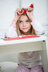 Image showing Thoughtful Girl Holding Santa Headband