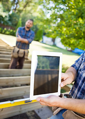 Image showing Cropped Image Of Carpenter Holding Digital Tablet At Site