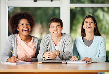 Image showing Student With Friends Sitting At Desk In Classroom