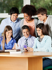 Image showing Teacher And Students Discussing Over Mobilephone In Classroom