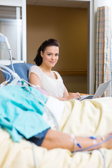 Image showing Woman With Laptop Sitting By Male Patient