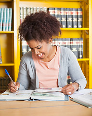 Image showing Student Writing In Book At University Library