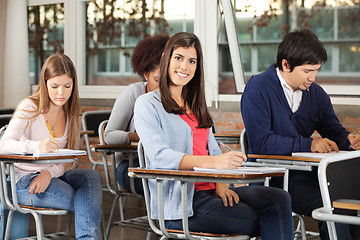 Image showing Woman With Students Writing Exam In Classroom