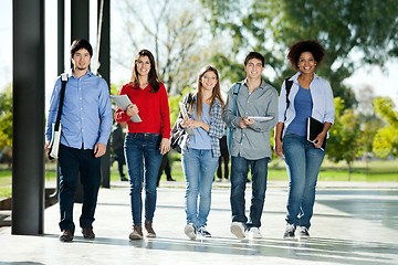 Image showing Confident Students Walking In A Row On Campus