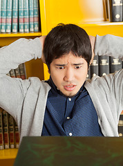 Image showing Student With Hands Behind Head Looking At Books In Library