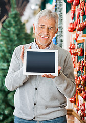 Image showing Happy Man Displaying Digital Tablet In Christmas Store