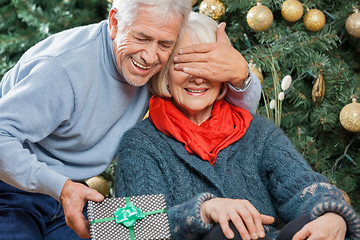 Image showing Man Surprising Senior Woman With Christmas Gifts