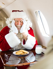 Image showing Santa With Cookies And Milk Sleeping In Private Jet