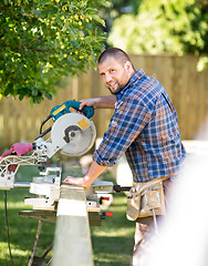Image showing Manual Worker Cutting Wood Using Table Saw At Site