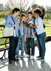 Image showing Friends Reading Book Together In College Campus