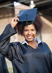 Image showing Student In Graduation Gown Wearing Mortar Board On Campus