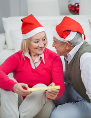 Image showing Senior Woman Holding Christmas Gift Looking At Man