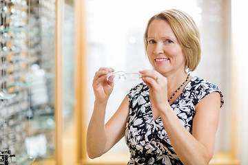 Image showing Woman Trying On Glasses At Optician Store