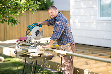 Image showing Carpenter Cutting Wood Using Table Saw At Site