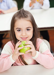 Image showing Girl Holding Smith Apple With Classmates In Background
