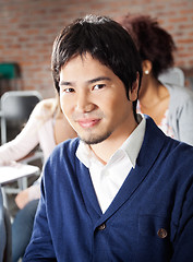 Image showing Student Sitting With Classmates In Background At Classroom