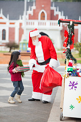 Image showing Santa Claus Giving Gift To Girl