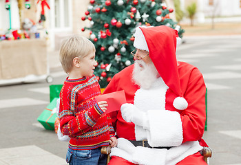 Image showing Santa Claus Taking Wish List From Boy