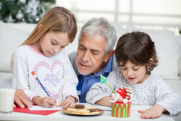 Image showing Grandfather Assisting Children In Writing Letters To Santa Claus