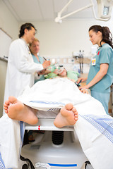 Image showing Doctor And Nurses Examining Patient's Medical Report