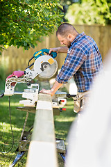 Image showing Worker Cutting Wood Using Table Saw At Site