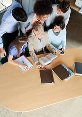 Image showing Teacher Discussing With Students At Desk In Classroom