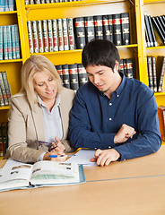 Image showing Teacher With Books Explaining Student In University Library