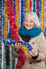 Image showing Woman Choosing Tinsels At Christmas Store