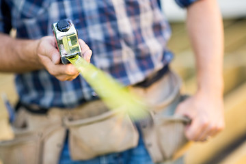 Image showing Cropped Image Of Carpenter Holding Tape Measure