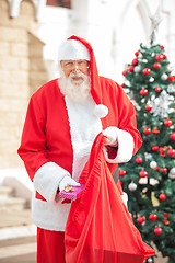 Image showing Santa Claus Putting Gift In Bag