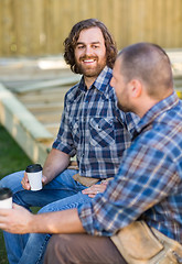 Image showing Worker Holding Disposable Cup While Looking At Coworker