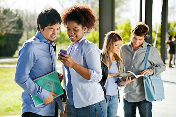 Image showing Students Reading Text Message On Mobilephone In Campus