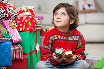 Image showing Thoughtful Boy Sitting By Christmas Gifts