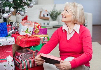 Image showing Senior Woman With Christmas Present Looking Away