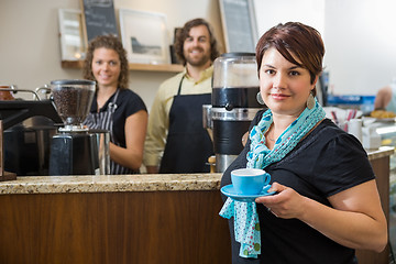 Image showing Customer Holding Coffee Cup With Workers At CafÃ©